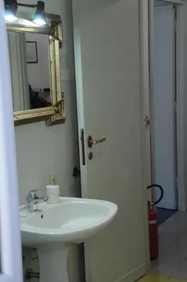 a bathroom with a white sink and a mirror at Appartamento 