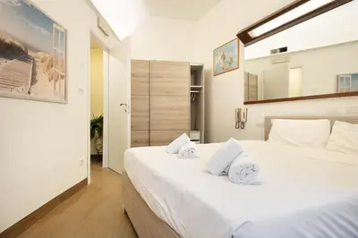 a bedroom with a large white bed with towels on it at Back to 70's-Modern and Terrace in Rome