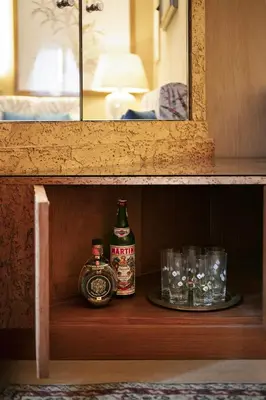 a shelf with two alcohol bottles and glasses on it at Back to 70's-Modern and Terrace in Rome