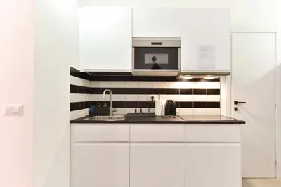 a white kitchen with a sink and a microwave at FanfullArt in Rome