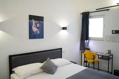 a bedroom with a bed and a yellow chair at FanfullArt in Rome