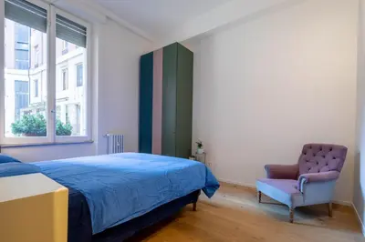 a bedroom with a bed and a chair and a window at Luna's Apartment BuddyRent in Rome