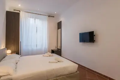 a bedroom with a bed and a tv on a wall at JOIVY Lovely Flats Next To Fontana di Trevi in Rome
