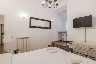 a white room with a tv on the wall at JOIVY Lovely Flats Next To Fontana di Trevi in Rome