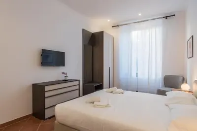 a bedroom with a white bed and a tv at JOIVY Lovely Flats Next To Fontana di Trevi in Rome