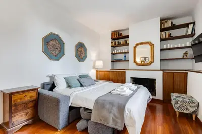 a bedroom with a bed and a chair and a mirror at BDC - Penthouse Brancaccio in Rome