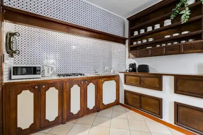 a kitchen with wooden cabinets and a microwave at BDC - Penthouse Brancaccio in Rome