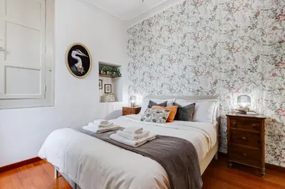a bedroom with a bed with a floral wallpaper at BDC - Penthouse Brancaccio in Rome