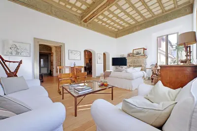 a living room with white furniture and a wooden ceiling at Piscinula in Rome