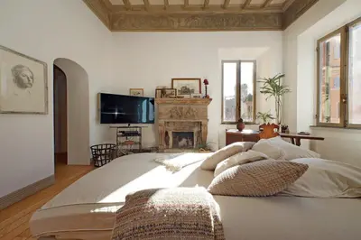 a bedroom with a large bed and a fireplace at Piscinula in Rome