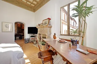 a living room with a table and a fireplace at Piscinula in Rome