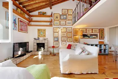 a living room with a white couch and a fireplace at Spagna in Rome