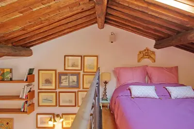 a bedroom with a purple bed and wooden ceilings at Spagna in Rome