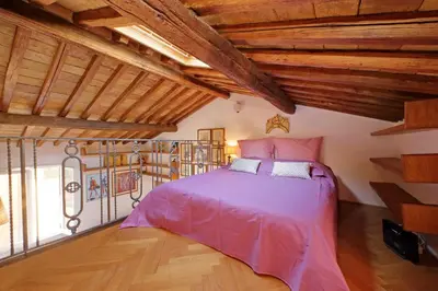 a bedroom with a pink bed and wooden ceilings at Spagna in Rome
