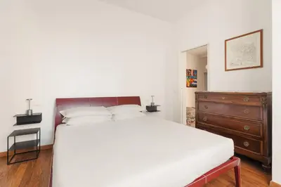 a bedroom with a large white bed and a dresser at Vatican Lovely 2BR Apartment with Terrace in Rome