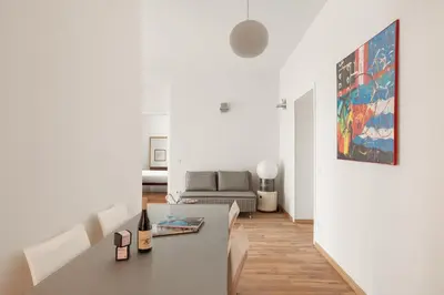 a white living room with a table and a couch at Vatican Lovely 2BR Apartment with Terrace in Rome