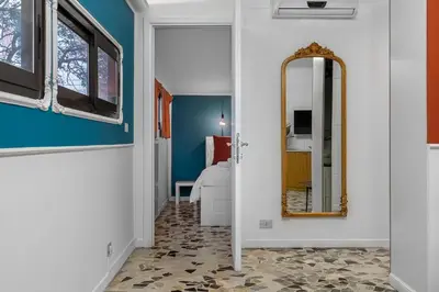 a hallway with a mirror and blue walls at Flaminio Charme Apartment in Rome