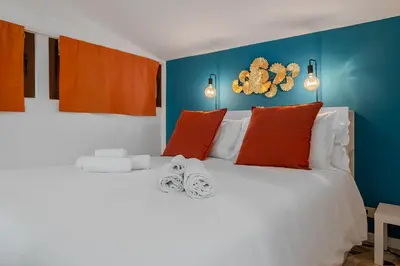 a bedroom with a white bed with orange and blue walls at Flaminio Charme Apartment in Rome
