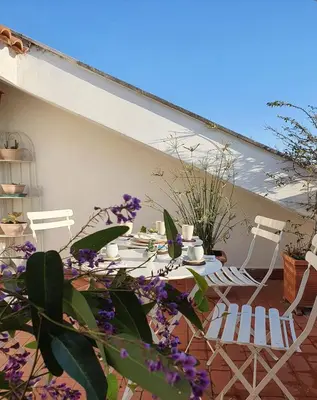 a patio with two chairs and a table with purple flowers at Appartamento 