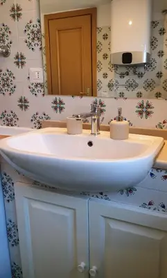 a bathroom with a white sink and a mirror at Appartamento 