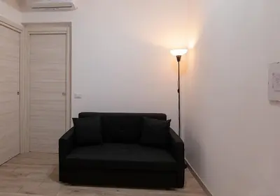 a black couch in a living room with a lamp at Lucy's Roof in Rome