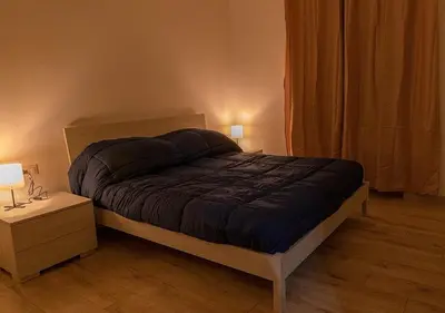 a bedroom with a bed and a night stand with two lamps at Lucy's Roof in Rome