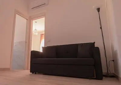 a black couch in a living room with a lamp at Lucy's Roof in Rome