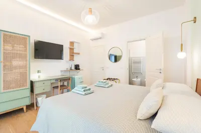a white bedroom with a bed and a desk at Supreme Apartments Vaticano in Rome