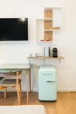 a room with a desk and a small white refrigerator at Supreme Apartments Vaticano in Rome
