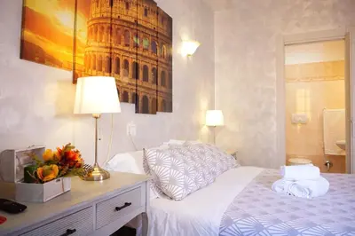 a bedroom with a bed and a table with a lamp at Rossana House in Rome