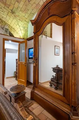 a large wooden mirror in a room with a tv at DOMUS GELSOMINO in Rome