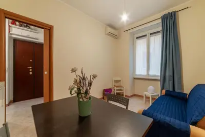 a living room with a blue couch and a table at GuestHost - Piazzale delle Provincie Apartment in Rome