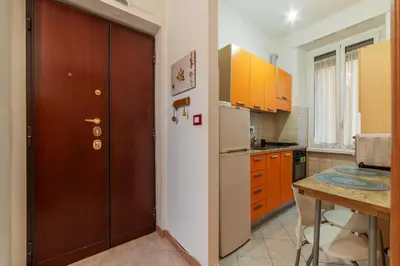 a kitchen with a refrigerator and a table in it at GuestHost - Piazzale delle Provincie Apartment in Rome