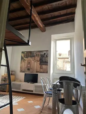 a living room with a table and chairs and a television at Anna’s home in Rome