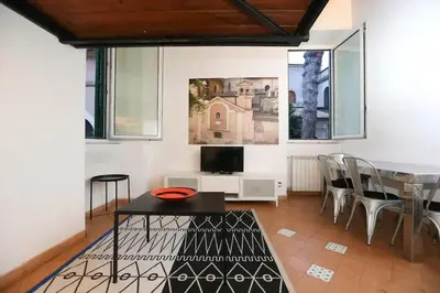 a living room with a table and chairs and a tv at Anna’s home in Rome