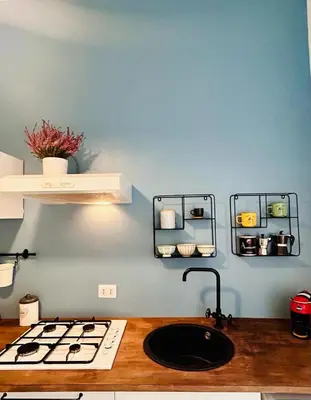 a kitchen with a sink and a blue wall at La Casa di Testaccio Apartment in Rome