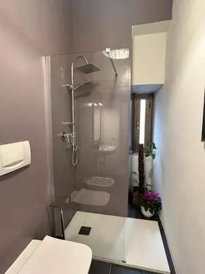 a bathroom with a glass shower with a toilet at La Casa di Testaccio Apartment in Rome