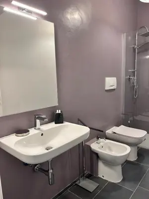 a bathroom with a sink and a toilet and a mirror at La Casa di Testaccio Apartment in Rome