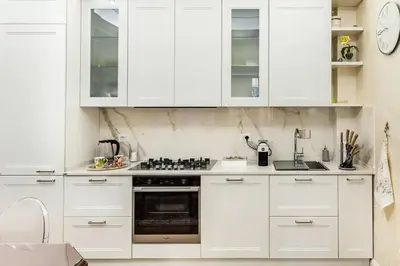 a white kitchen with white cabinets and a stove at Menotti elegant apartment in Rome