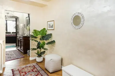 a living room with a mirror and a plant at Menotti elegant apartment in Rome