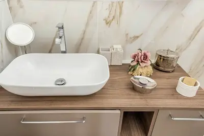 a bathroom with a white sink on a wooden counter at Menotti elegant apartment in Rome