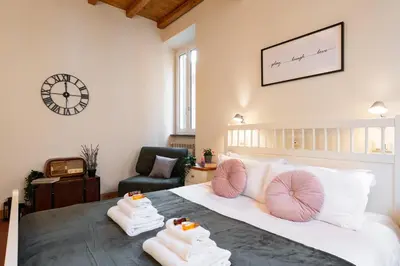 a bedroom with a bed with pillows and a clock at Orso 70 apartment in Rome