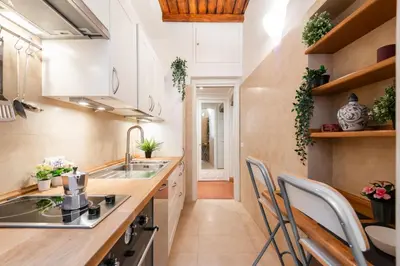 a kitchen with a sink and a counter with chairs at Orso 70 apartment in Rome