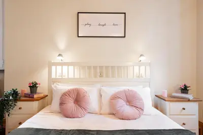 a bedroom with a bed with pink pillows on it at Orso 70 apartment in Rome