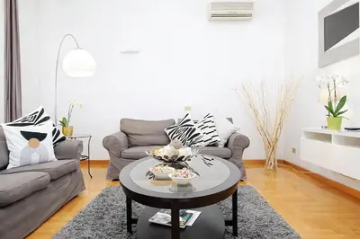 a living room with a couch and a table at Luxury Apartment for 10 Central VATICANO S'Peter Basilica AirCond NETFLIX - SKY Wifi in Rome