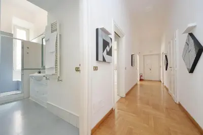 a hallway with white walls and a hardwood floor at Luxury Apartment for 10 Central VATICANO S'Peter Basilica AirCond NETFLIX - SKY Wifi in Rome