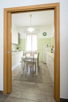 a kitchen with white cabinets and a table and chairs at La Maison de la Couturière in Rome