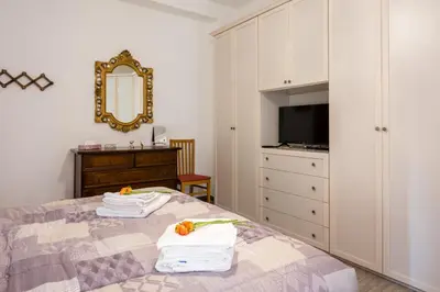 a bedroom with a bed and a dresser and a mirror at La Maison de la Couturière in Rome