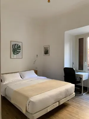 a white bedroom with a bed and a desk at Flat Between The Vatican and Piazza del Popolo in Rome