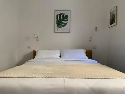 a large white bed in a white bedroom at Flat Between The Vatican and Piazza del Popolo in Rome